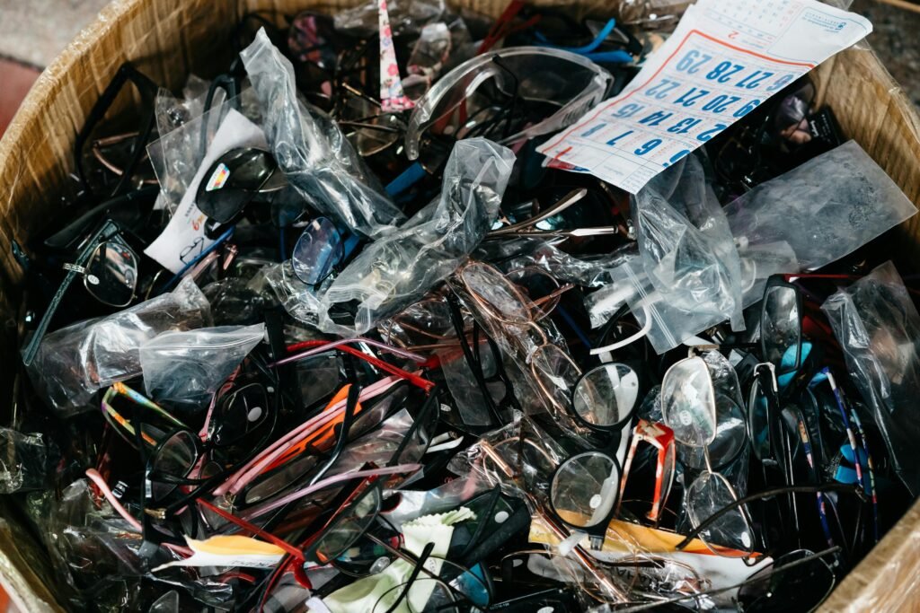 A diverse collection of eyeglasses and sunglasses in a cardboard box showcasing various styles